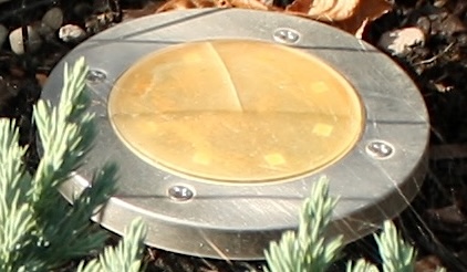 Close-up of a solar light with scratches, cobwebs, and LED's